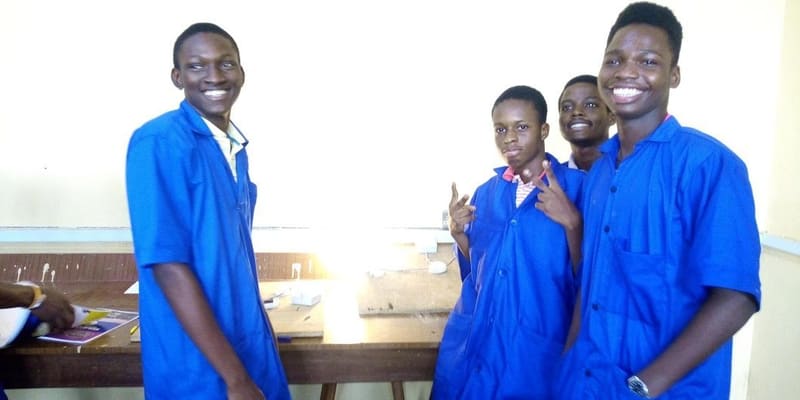 Students in blue lab coats in a laboratory