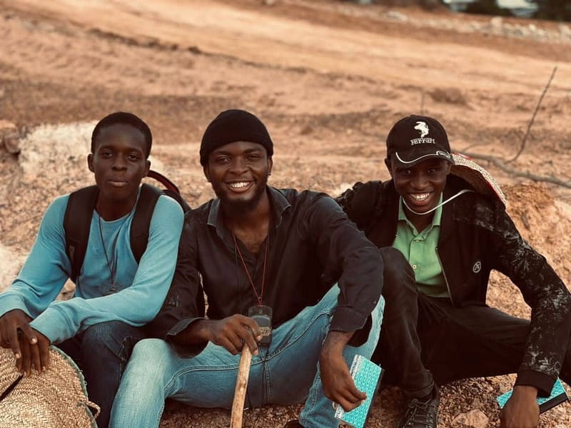 Three students seated on rocks at a quarry