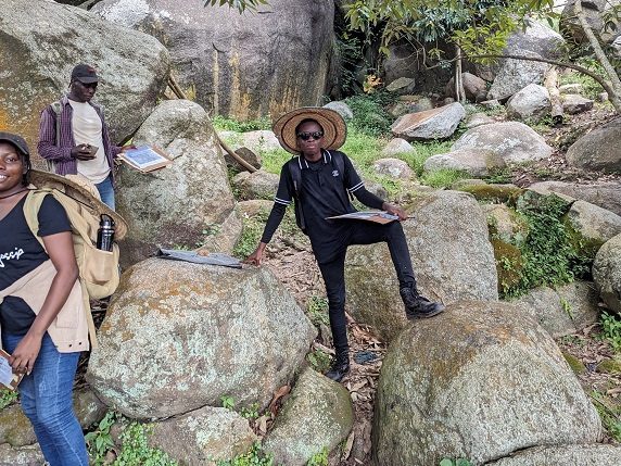 Students on large granite boulders during field mapping